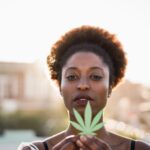young-african-girl-holding-marijuana-leaf-focus-2021-10-20-00-26-09-utc